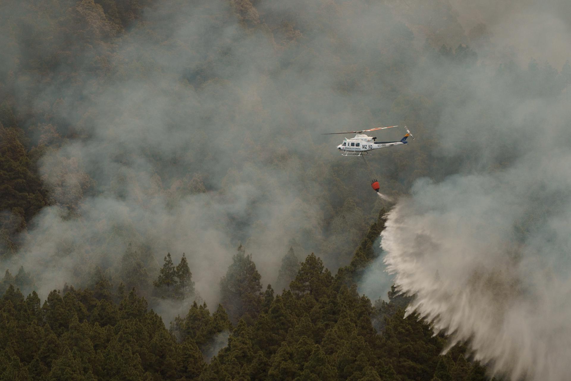 Helicópteros trabajan en el pueblo de Aguamansa, en el municipio de La Orotava que ha sido evacuado a consecuencia de la cercanía del incendio forestal que afecta a varios municipios de la isla de Tenerife. EFE/Ramón de la Rocha