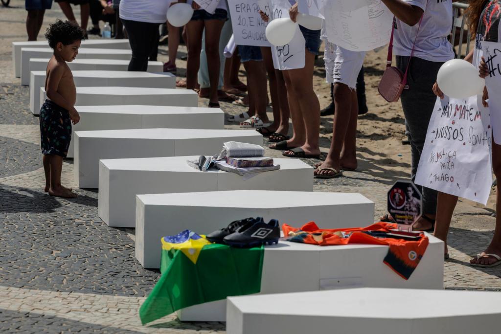 Personas participan en una protesta de la ONG Rio de Paz para homenajear a las víctimas civiles como consecuencia de las acciones policiales, hoy, en la playa de Copacabana, en Río de Janeiro (Brasil). EFE/Antonio Lacerda
