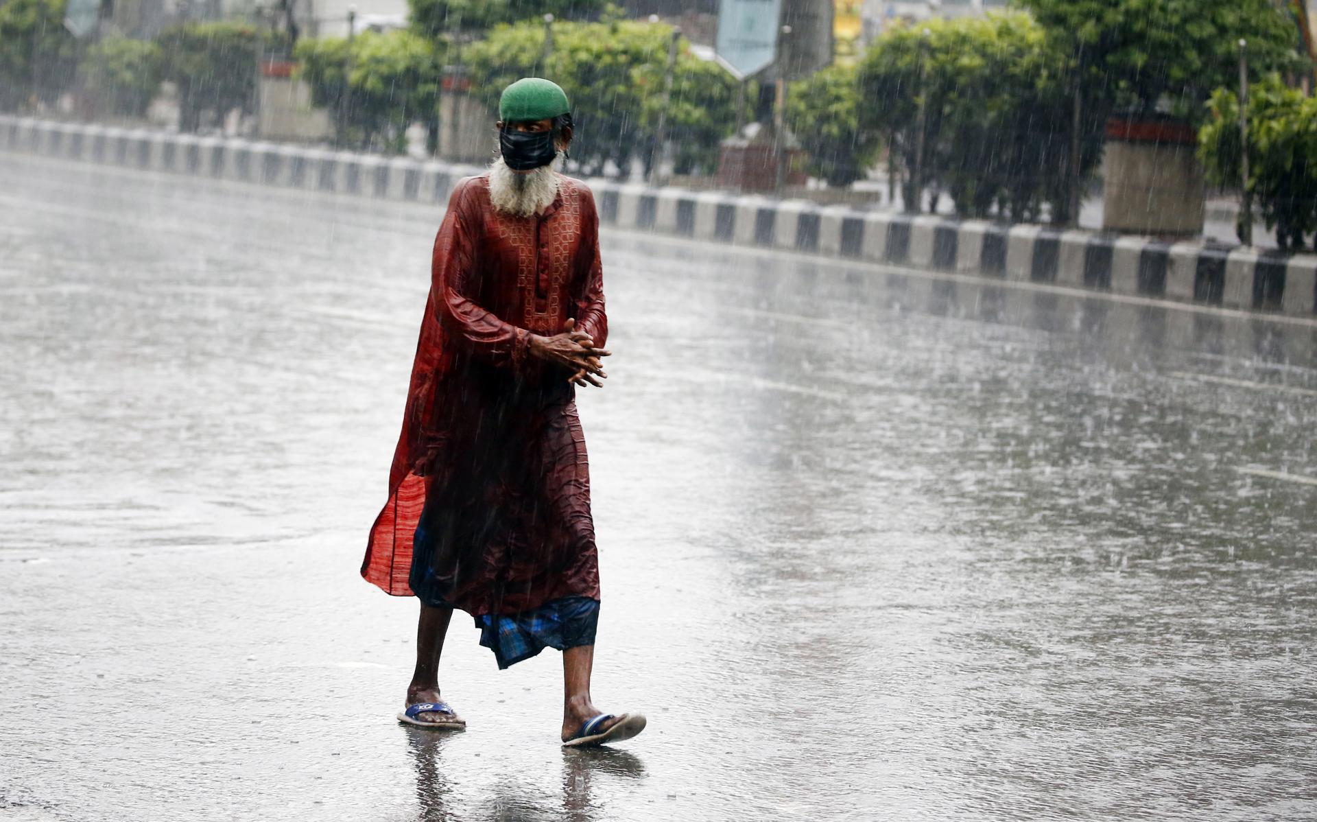 An elderly man wears a protective face mask while walking on the street as it rains in Dhaka, Bangladesh, 26 April 2020. EFE-EPA/FILE/MONIRUL ALAM