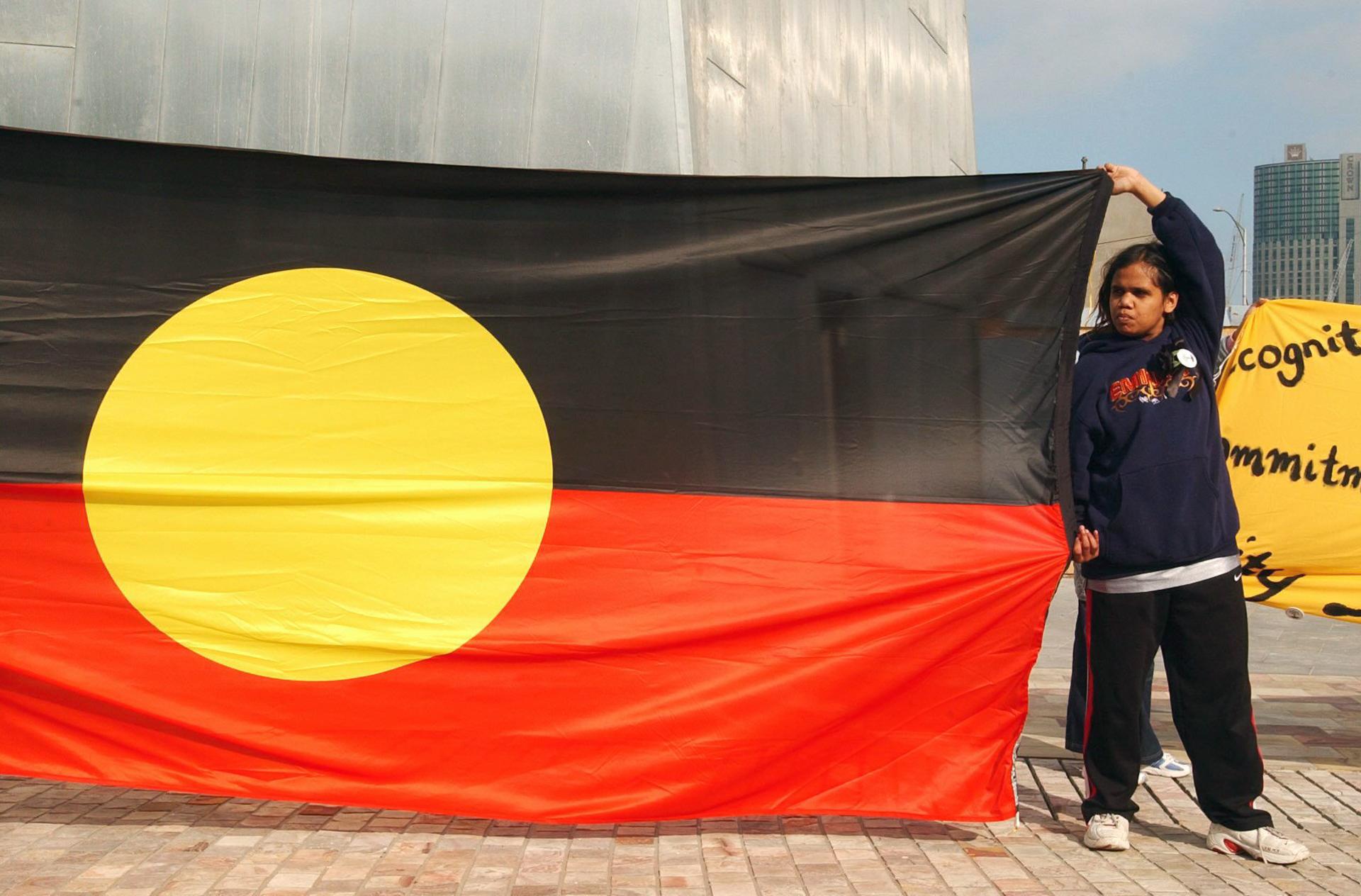 A girl holds the Aboriginal flag at a gathering in Federation Square in Melbourne on Monday 26 May 2003. EPA FILE/AAP/JOE CASTRO AUSTRALIA AND NEW ZEALAND OUT
