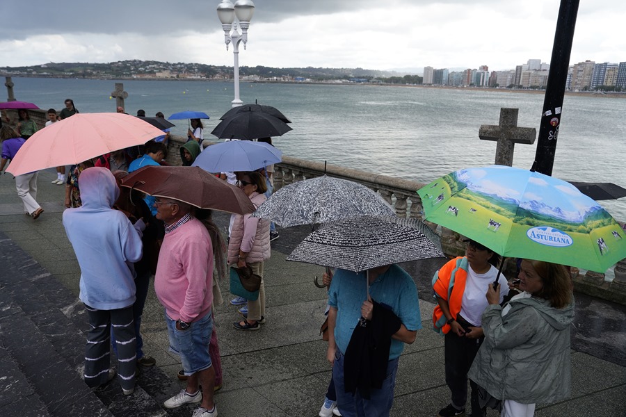 turistas bajo los paraguas en la Iglesia de San Pedro en la playa de San Lorenzo