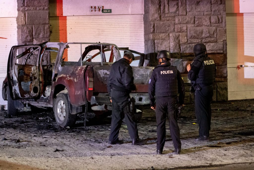 Policías investigan los restos de un carro bomba que explotó en las primeras horas del 31 de agosto de 2023 en los exteriores del edificio del Servicio Nacional de Atención Integral a Personas Privadas de Libertad (SNAI), en Quito (Ecuador). EFE/STR