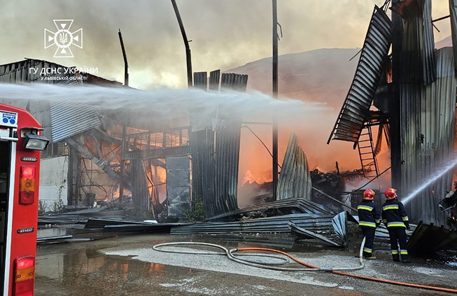 Imagen facilitada por el Servicio Estatal de Emergencia ucraniano de las labores de extinción de un incendio declarado en un almacén industrial de Leópolis, en el oeste de Ucrania, en el que impactaron fragmentos de un dron