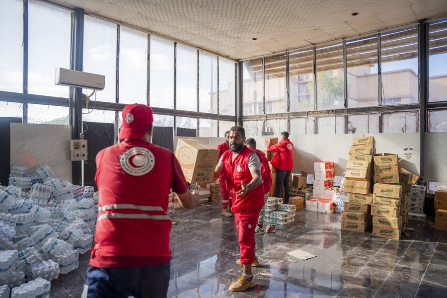 Equipos de emergencia de Media Luna Roja preparan material de ayuda para los afectados por inundaciones que arrasaron el noreste de Libia, en un almacén de Trípoli