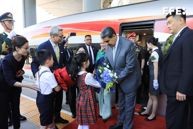 Fotografía cedida por Prensa Miraflores que muestra al presidente venezolano, Nicolás Maduro (c) con unos niños, en su llegada a Pekín