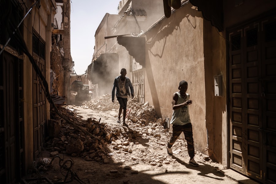 Dos personas caminan sobre los escombros de un edificio dañado por el terremoto dentro de la Medina de Marrakech, Marruecos, este lunes