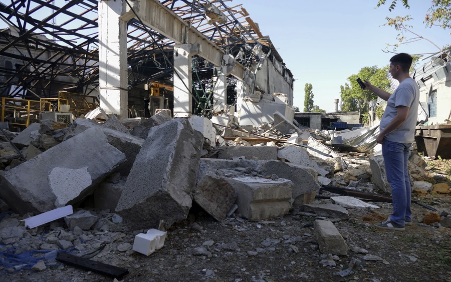 Un hombre observa los daños causados en una fábrica después de un bombardeo nocturno en Odesa, sur de Ucrania