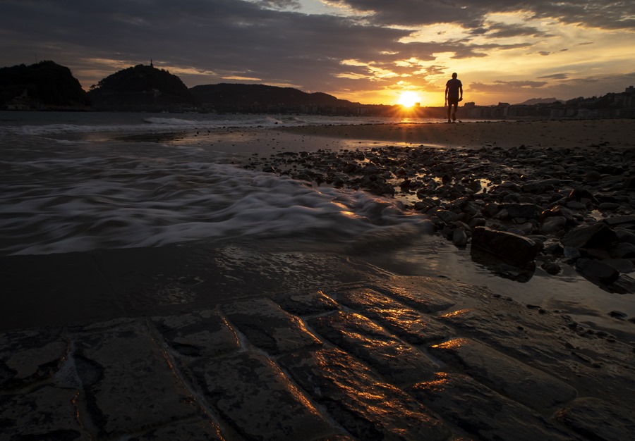 Un hombre pasea este viernes al amanecer por la playa de Ondarreta.