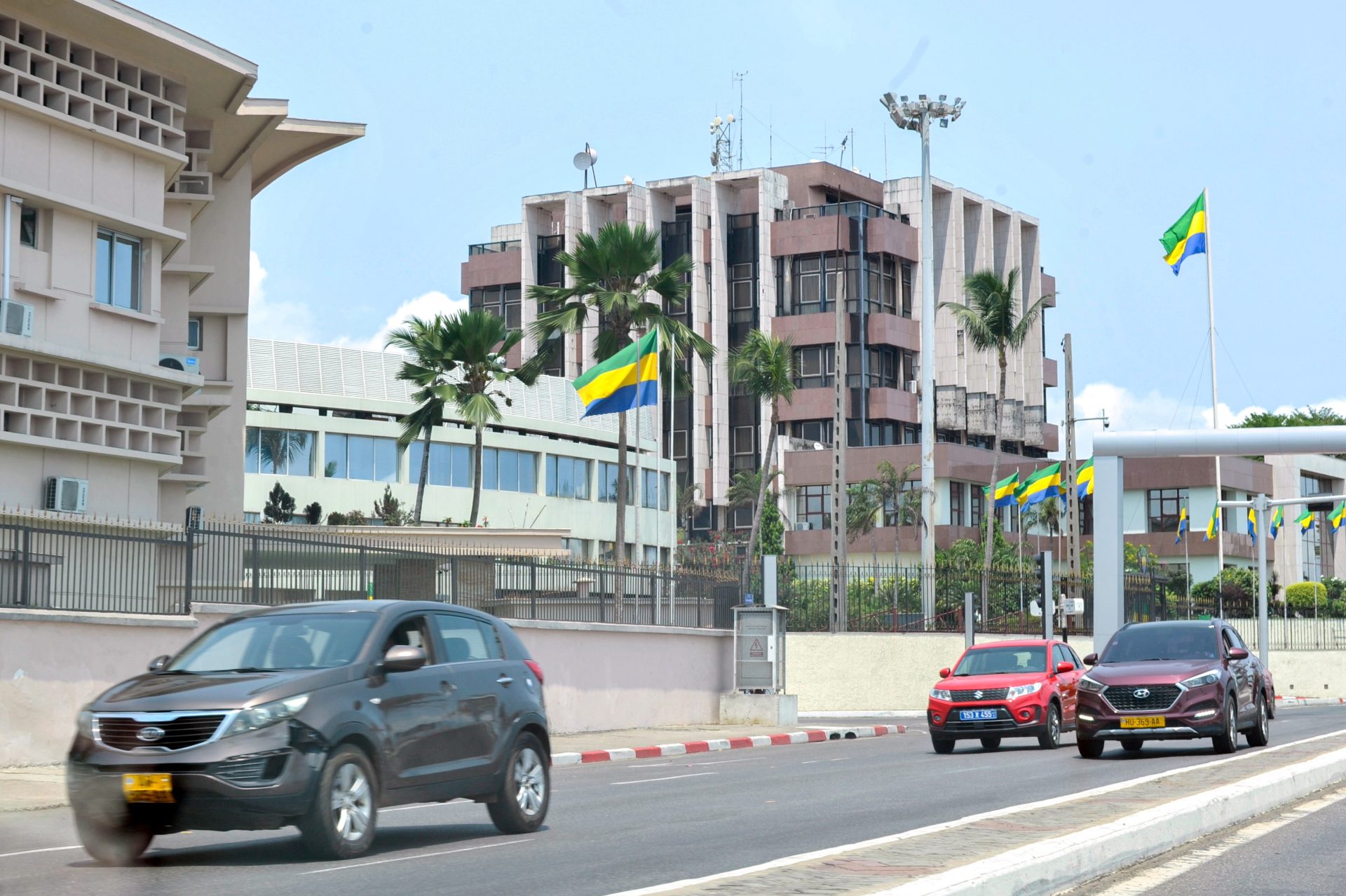 Coches pasan por delante de la entrada del Palacio Presidencial en Gabón.