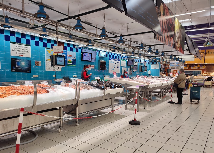 Varias personas compran pescado y mariscos en un supermercado de Madrid