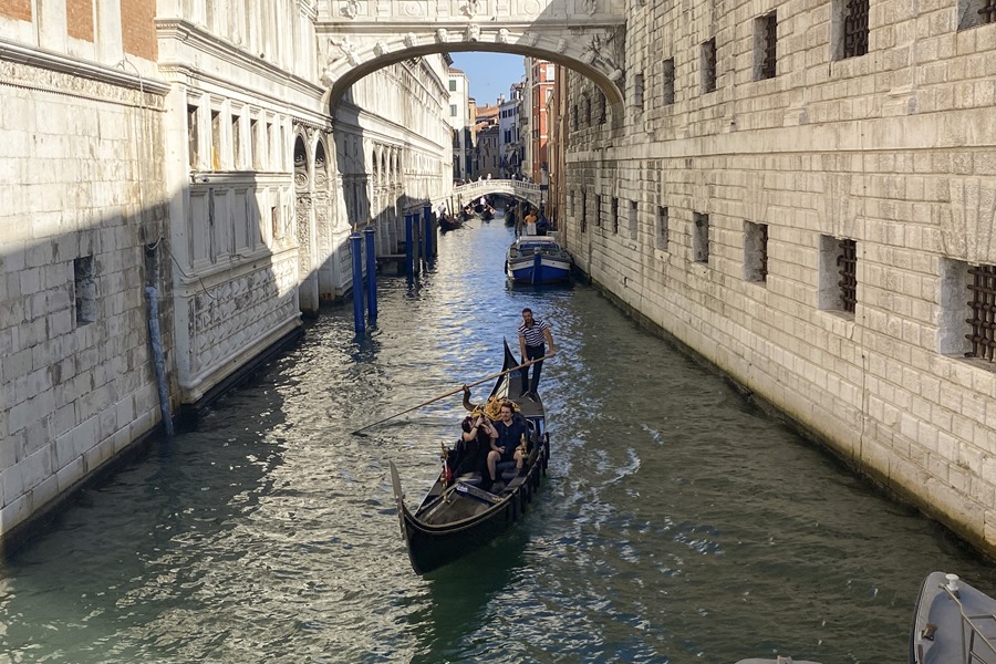 Una pareja disfruta de un viaje en góndola por un canal de Venecia.