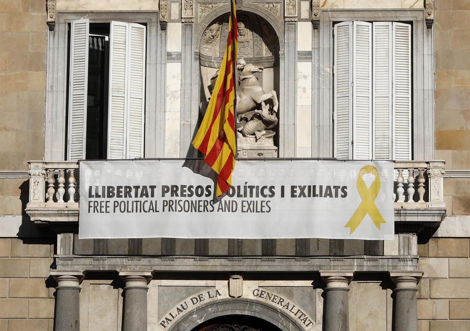 Vista del cartel reclamando la libertad de los líderes independentistas presos y un lazo amarillo en la fachada del Palau de la Generalitat.