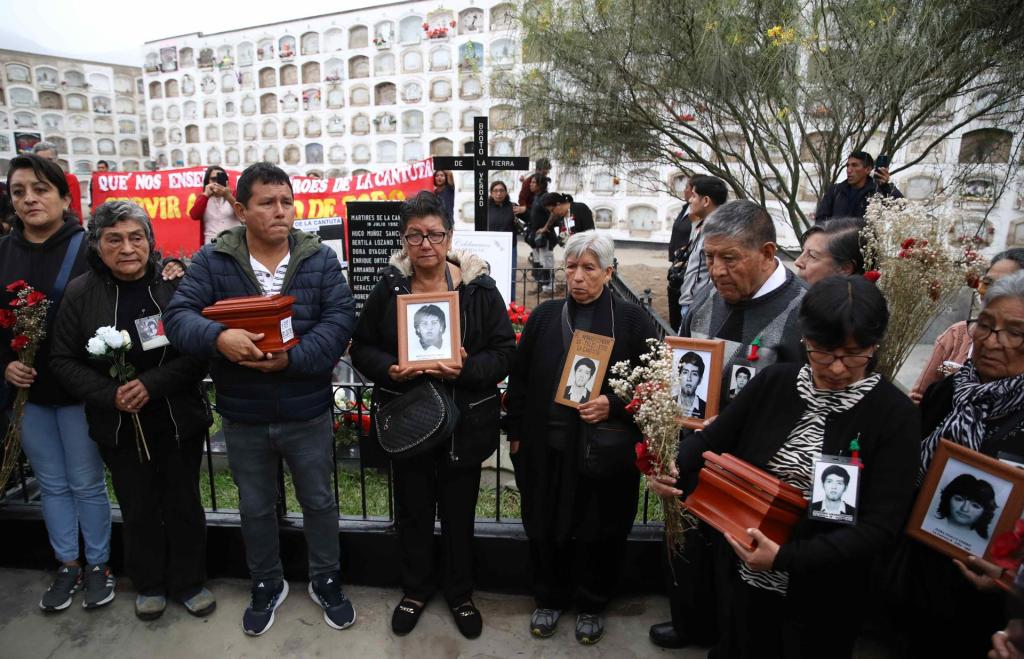 Familiares sostienen retratos de víctimas de la matanza de La Cantuta durante su funeral hoy, en Lima (Perú). EFE/Paolo Aguilar
