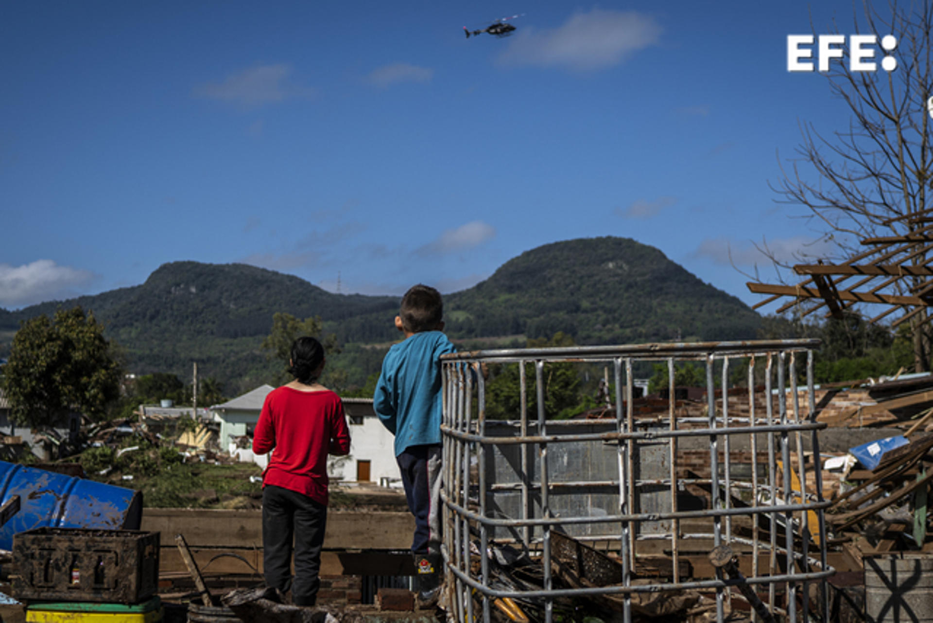 Two children observe the passage of a rescue helicopter among rubble after the passage of an extratropical cyclone, today, in Roca Sales, municipality of Rio Grande do Sul, Brazil, 6 September 2023. EFE/ Daniel Marenco
