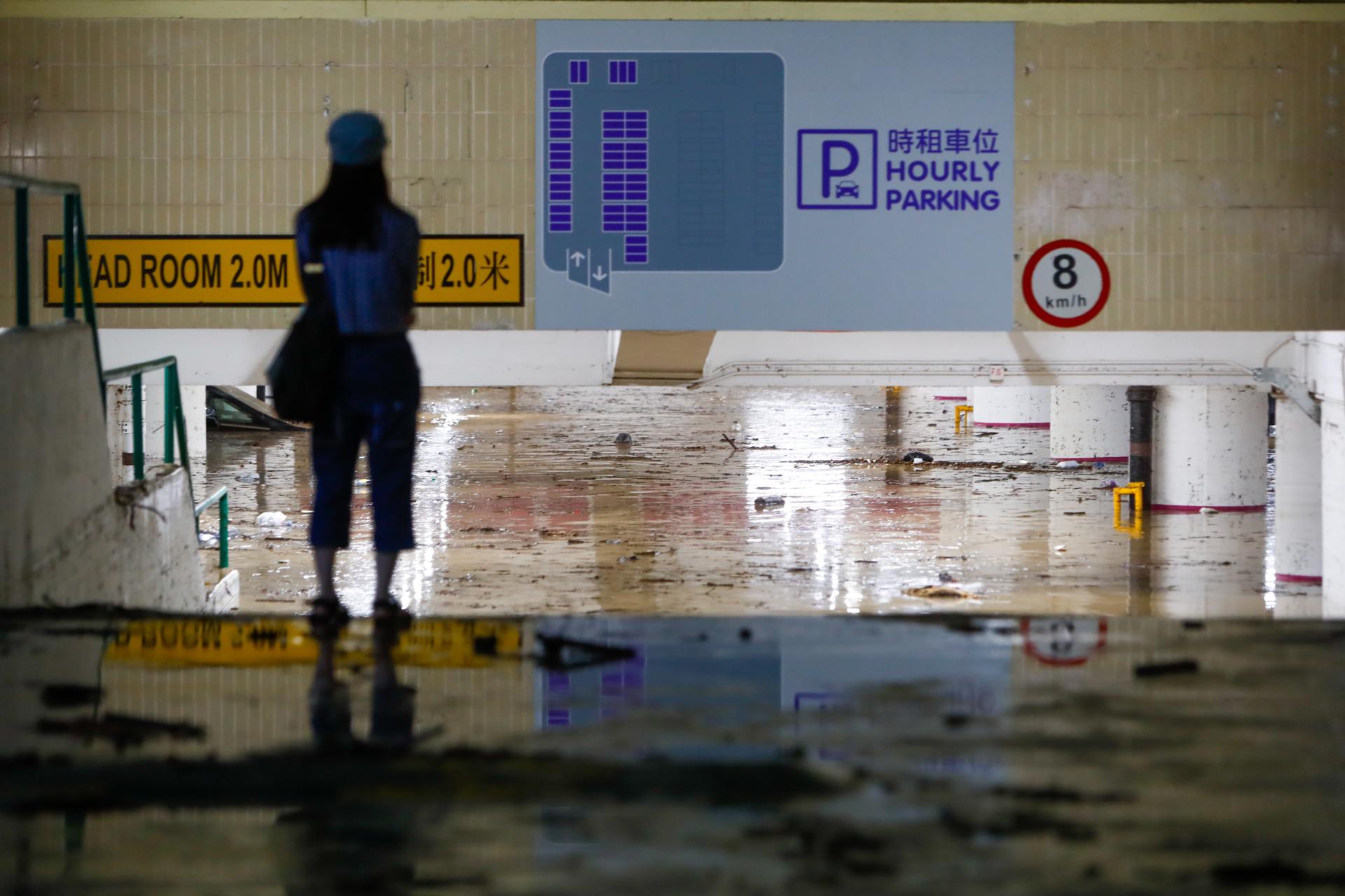 A woman stands in front of the entrance to a flooded car park following continued torrential rains hitting the city, in Hong Kong, China, 08 September 2023. EFE/EPA/DANIEL CENG