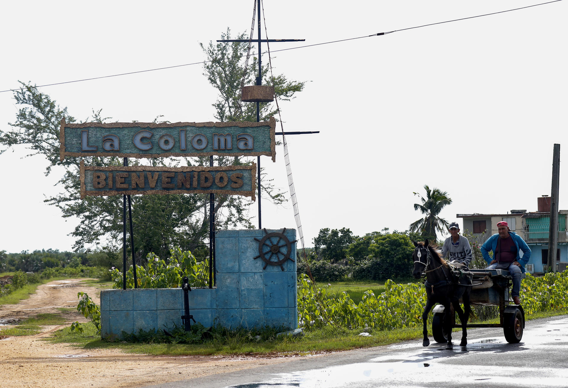 Two men travel on a cart in front of the entrance to the town of La Coloma, province of Pinar del Rio, Cuba, 27 September 2023. EFE/Yander Zamora