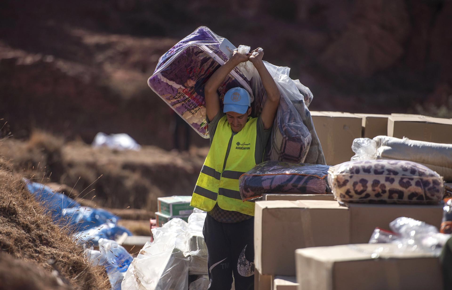 A volunteer carries goods to be distributed as support operations and the distribution of waterproof tents and aid continue, in the earthquake-hit village of Tifarouine, Morocco, 23 September 2023. EFE-EPA/STR