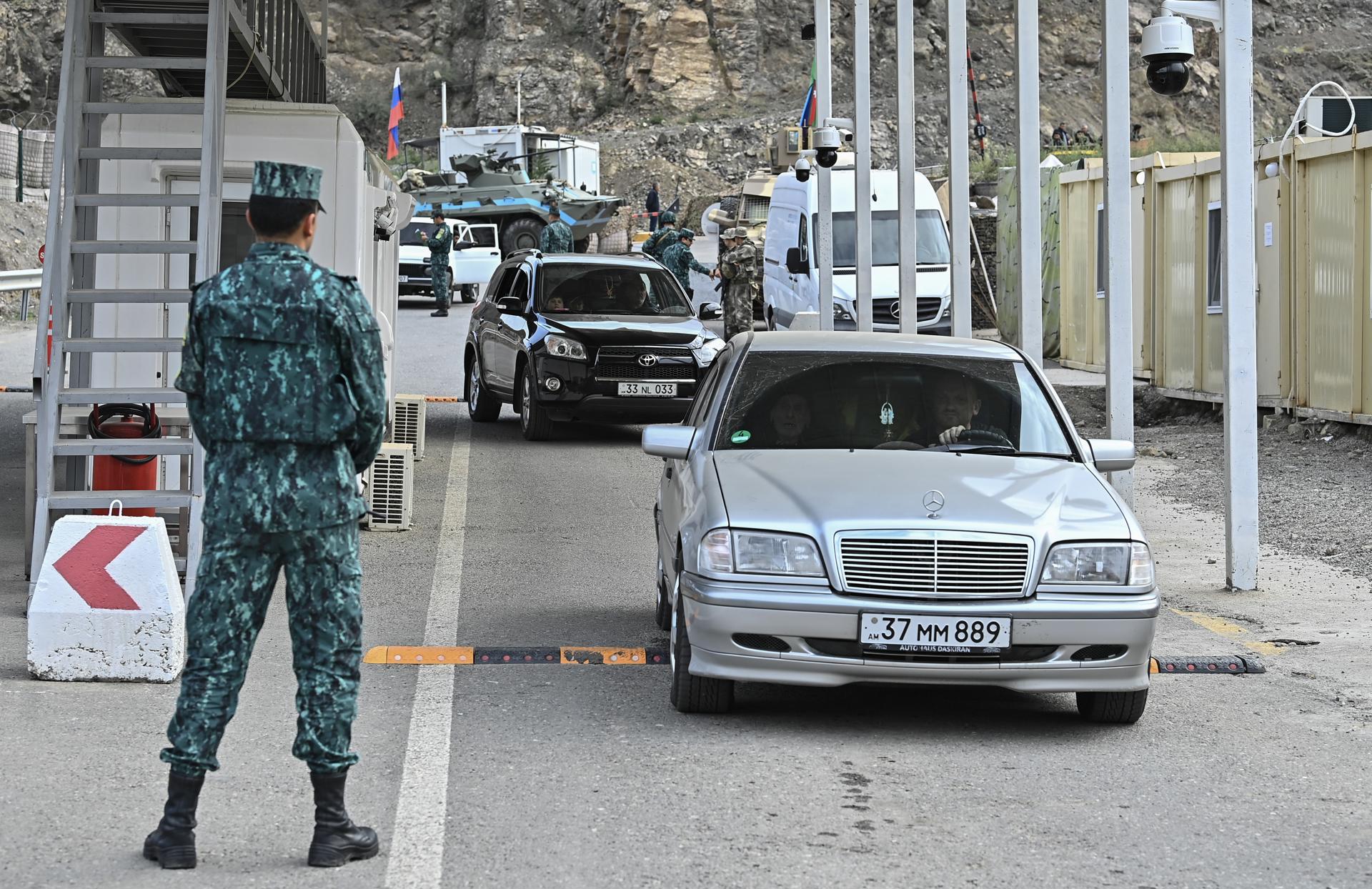 Azeri servicemen stand guard as ethnic Armenians leave Nagorno-Karabakh through a checkpoint on the entrance of the Lachinsky corridor, which connects the Nagorno-Karabakh region with Armenia, in Lachin, Azerbaijan, 25 September 2023. EFE-EPA/ROMAN ISMAYILOV
