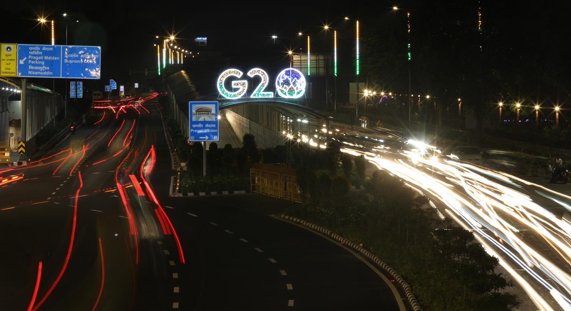 Vehicles drive past an illuminated G20 logo in New Delhi, India, 17 August 2023. EFE/EPA/FILE/RAJAT GUPTA TAKEN WITH SLOW SHUTTER SPEED