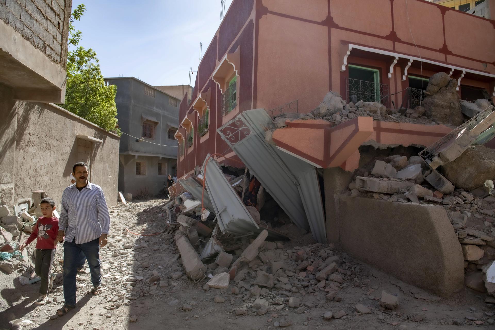 A person with a child walk next to a damaged building following an earthquake in Marrakesh, Morocco, 09 September 2023. EFE/EPA/JALAL MORCHIDI