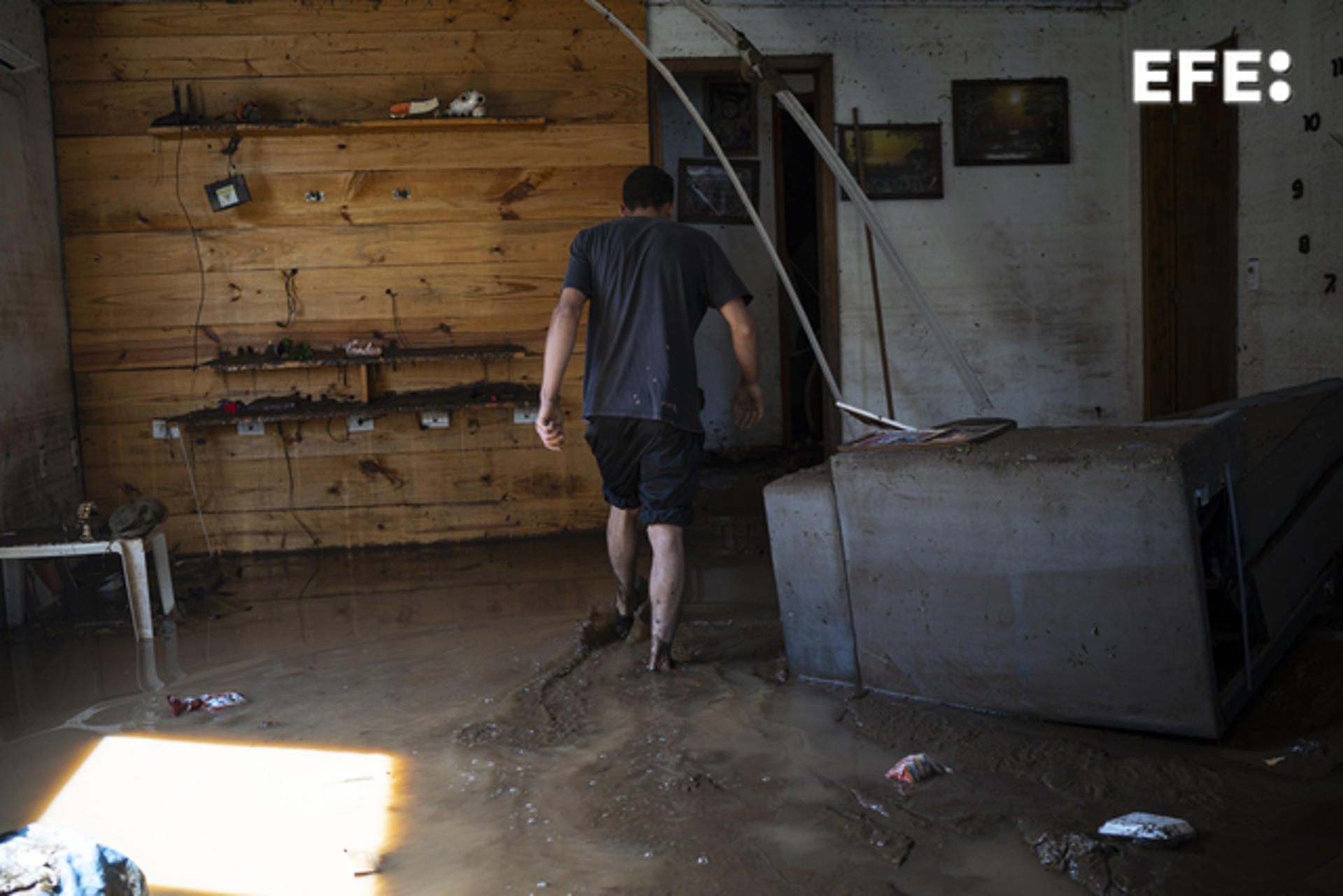 A man walks through mud inside his home after the passage of an extratropical cyclone, today, in Mucum, municipality of Rio Grande do Sul, Brazil, 6 September 2023. EFE/ Daniel Marenco
