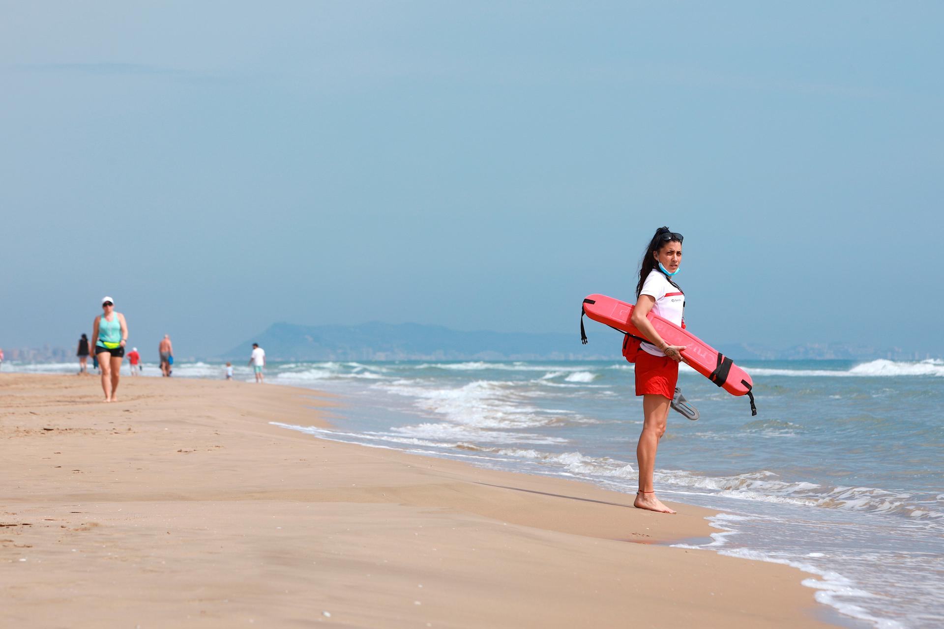 Una socorrista observa a los bañistas que, este lunes, en la playa de Gandia. EFE/Natxo Francés/Archivo