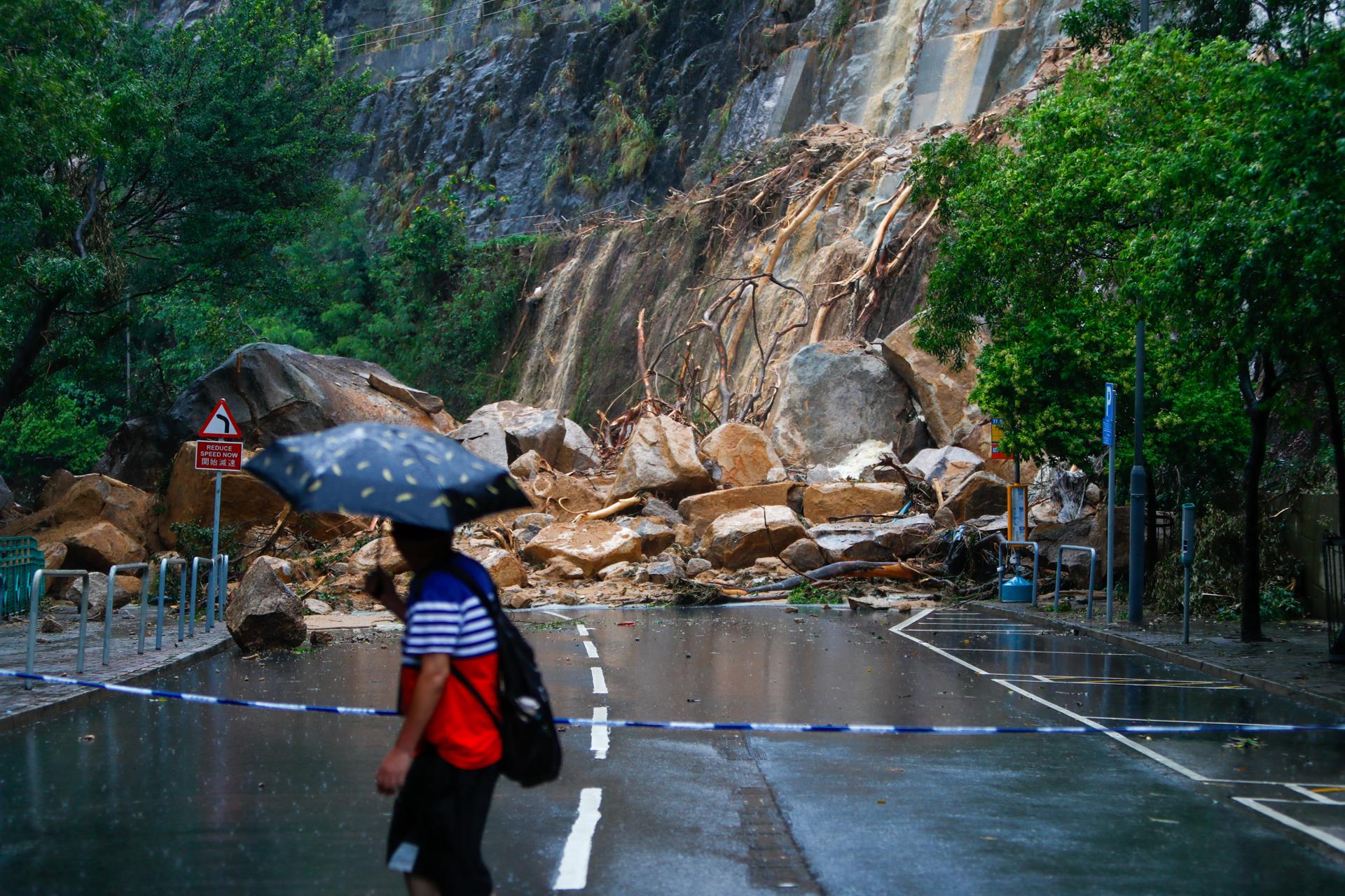 A man views the debris of a landslide blocking a road following torrential rains hitting the city, in Hong Kong, China, 08 September 2023. EFE/EPA/DANIEL CENG
