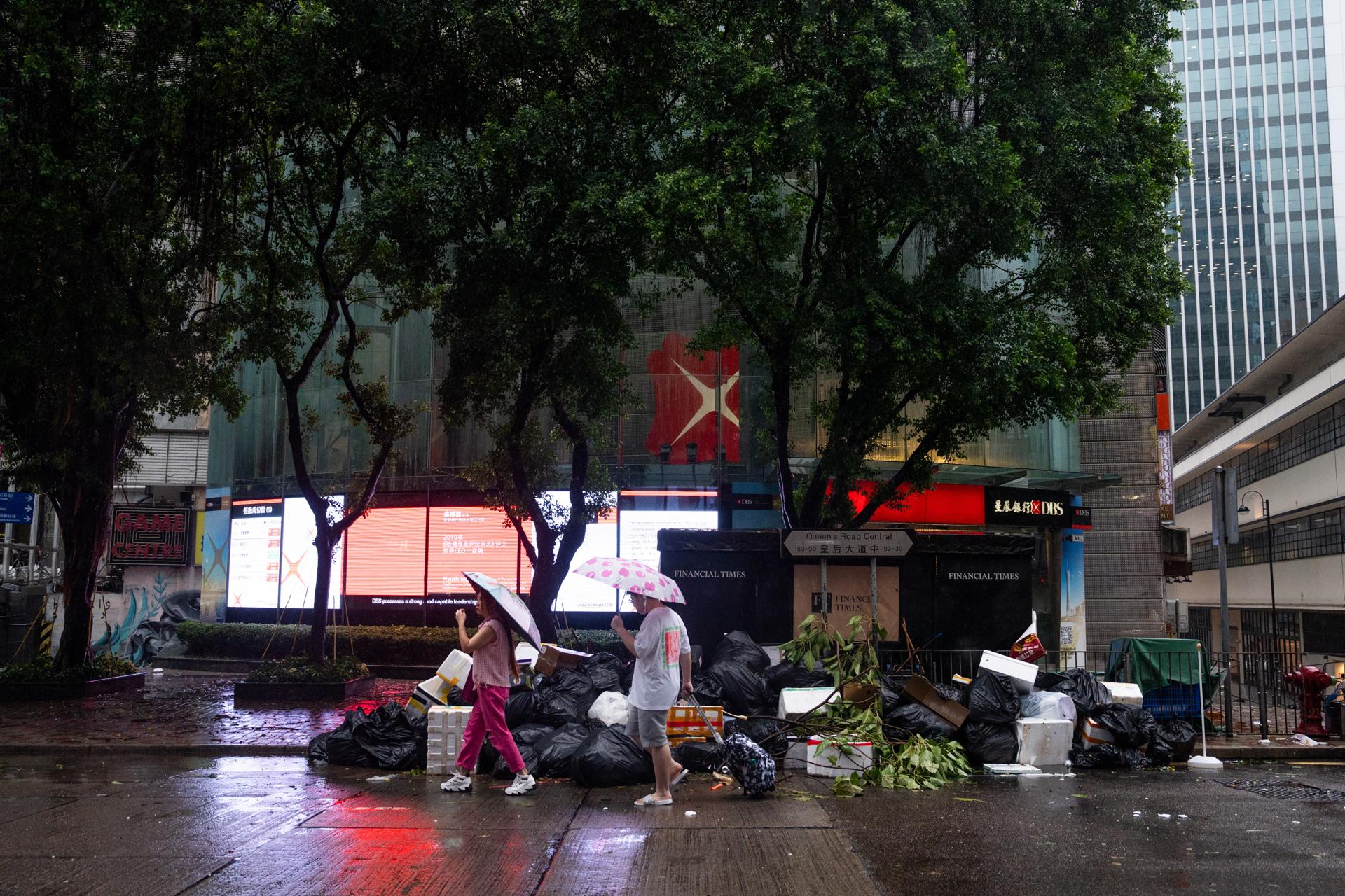 Hong Kong (China), 02/09/2023.- People walk past garbage piled up on a road in the aftermath of Typhoon Saola, in Central, Hong Kong, China, 02 September 2023. The No. 10 typhoon warning, for the first time since 2018, was raised on the night of 01 September as Typhoon Saola swept past Hong Kong. EFE/EPA/Bertha Wang

