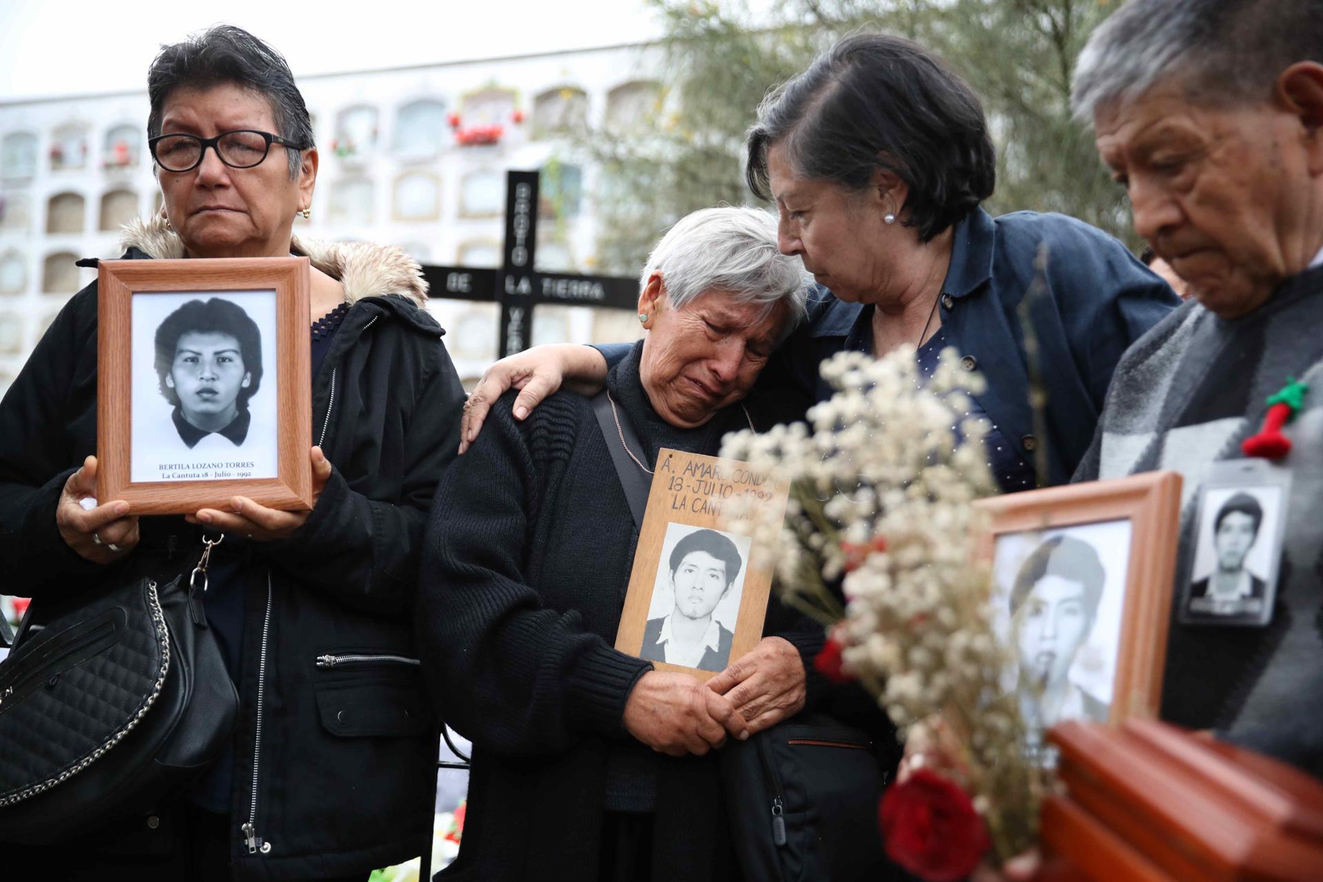 Familiares sostienen retratos de víctimas de la matanza de La Cantuta durante su funeral hoy, en Lima (Perú). EFE/Paolo Aguilar