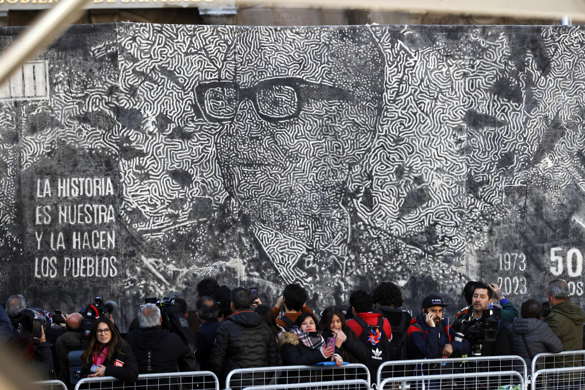 Un grupo de personas, frente a una imagen del derrocado presidente de Chile Salvador Allende, fue registrado este lunes, 11 de septiembre, durante un acto ciudadano en Conmemoración de los 50 años del Golpe de Estado en contra de Allende, a las afueras del Palacio de La Moneda, en Santiago de Chile.