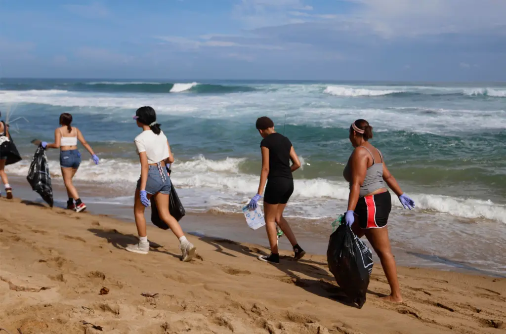 Personas recolectan basuras en una playa hoy, durante el Día Internacional de Limpieza de Costas, en San Juan (Puerto Rico). EFE/Thais Llorca
