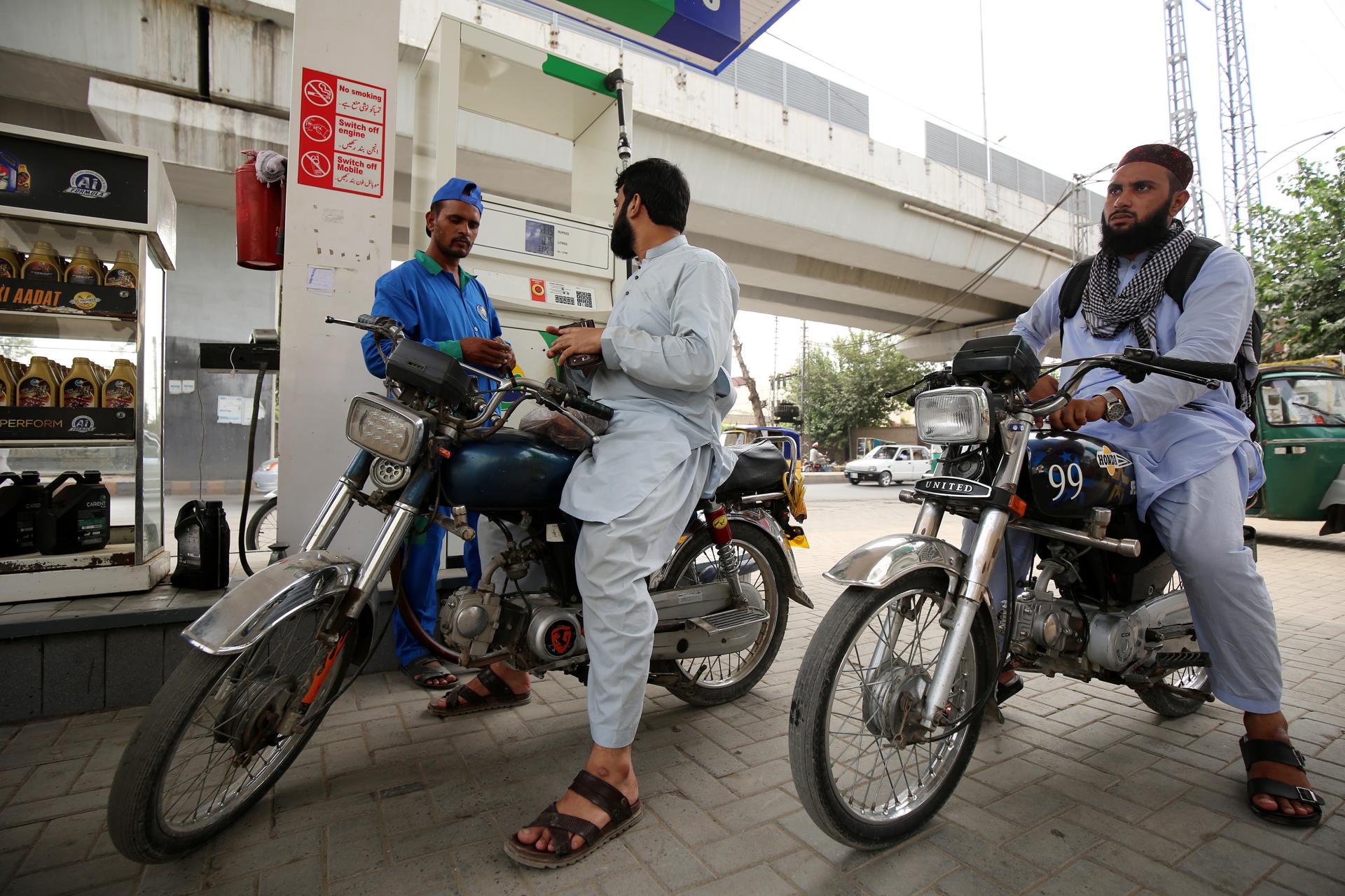 A gas station attendant refuels a motorcycle in Peshawar, Pakistan, 16 September 2023. EFE-EPA/ARSHAD ARBAB