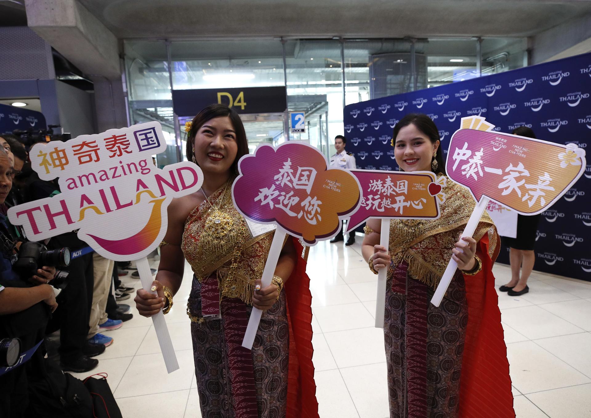 Thai officials hold banners to welcome Chinese tourists during a welcoming ceremony to mark the first day of the government's visa-free scheme at Suvarnabhumi International Airport in Samut Prakan province, Thailand, 25 September 2023. EFE/EPA/RUNGROJ YONGRIT