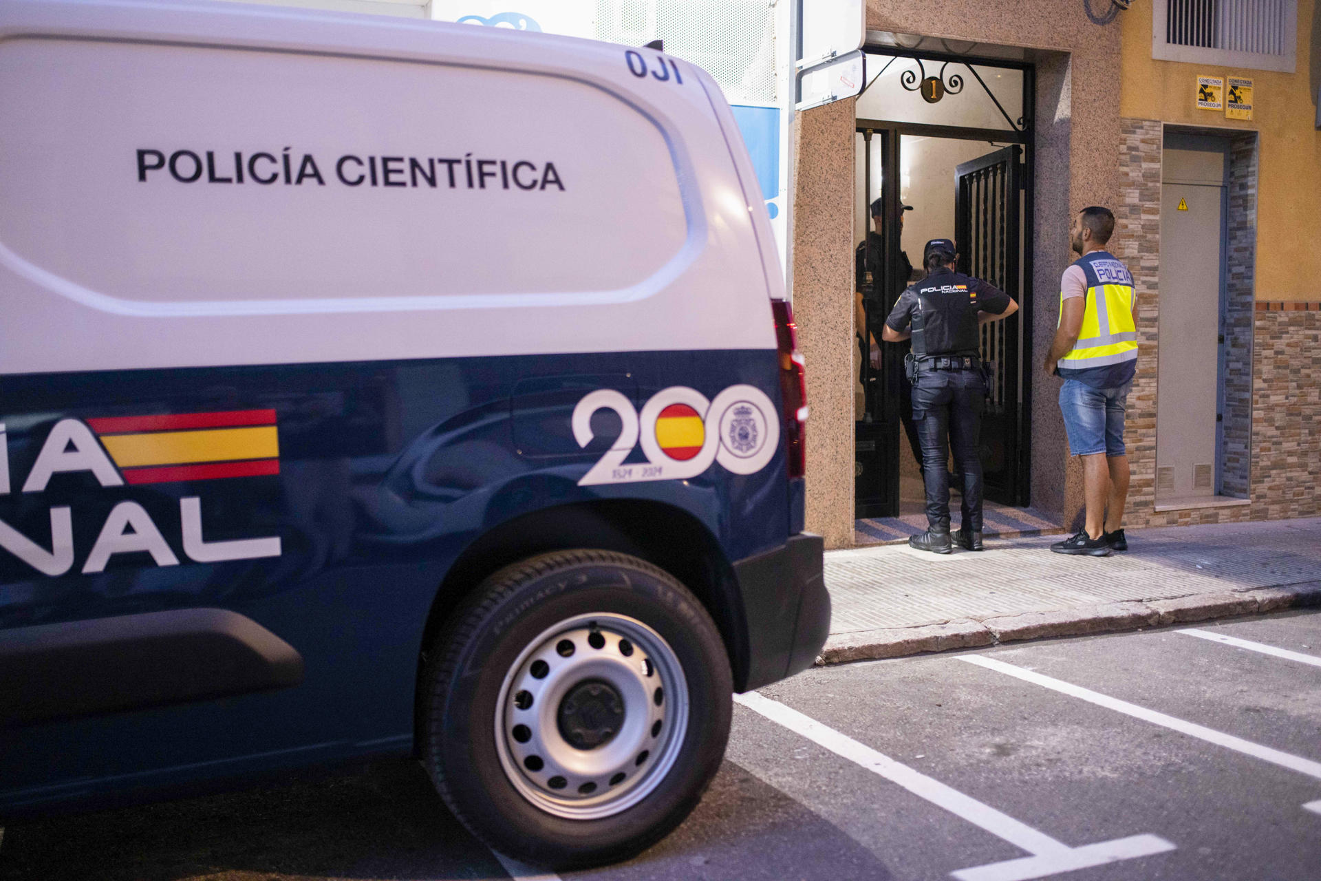 Un equipo de Policía Científica en la puerta del inmueble de Castellón donde han sido hallados los cadáveres de una mujer junto al de su pareja, un hombre que se había ahorcado, y que se investiga como un posible caso de violencia de género EFE/ Andreu Esteban