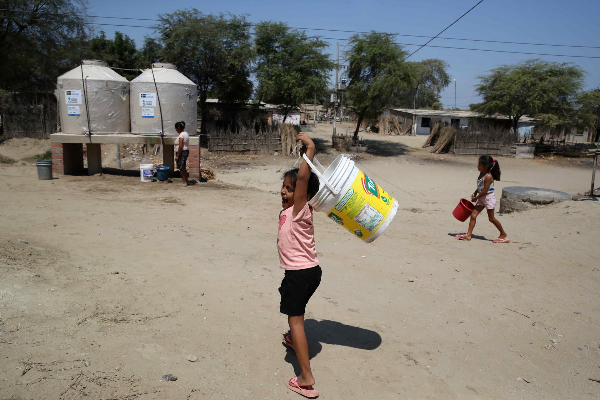 Children carry buckets to fill them with water in the drums installed by Action Against Hunger, in the human settlement of Mocara, department of Piura, Peru, 19 September 2023. EFE/Paolo Aguilar
