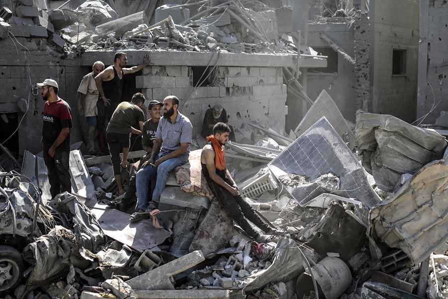 Ciudadanos palestinos sobre las ruinas de edificios de Gaza.