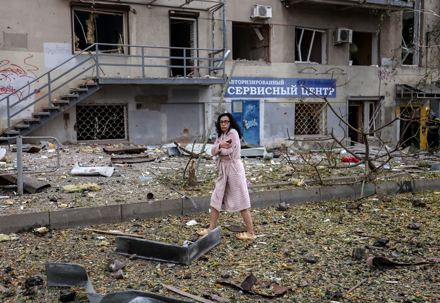 Una mujer camina entre los escombros de un edificio tras un ataque con cohetes contra Járkov