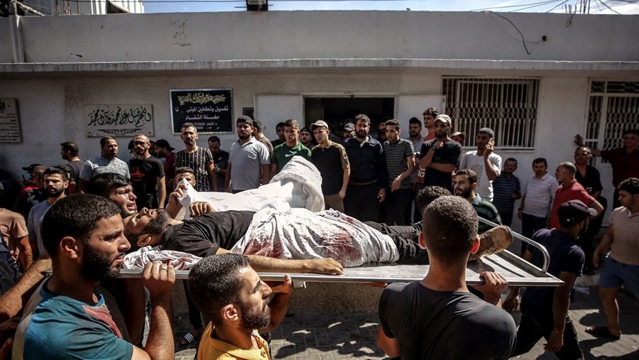 Palestinians carry the body of a fighter killed during the storming of Israel settlements by militants of the Ezz Al-Din Al Qassam militia, the military wing of Hamas movement, in Al-Shifa hospital in Gaza City, 07 October 2023. EFE-EPA/HAITHAM IMAD