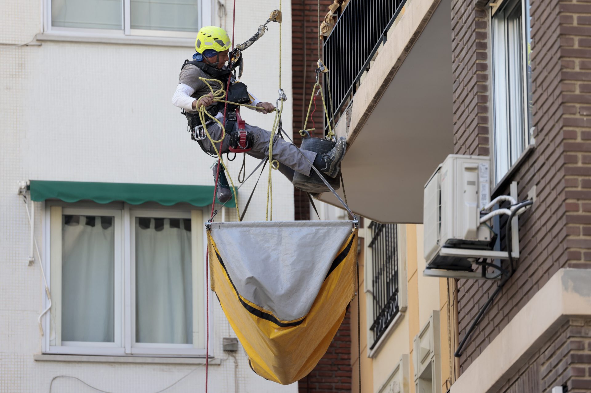Un trabajador de altura repara una fachada. EFE/Ana Escobar