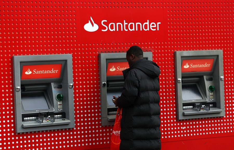 Un cliente saca dinero en un cajero del Banco Santander en Londres. 