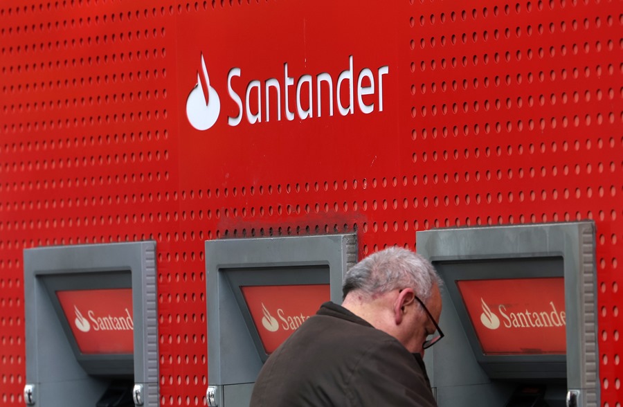 Un cliente saca dinero en un cajero del Banco Santander en Londres