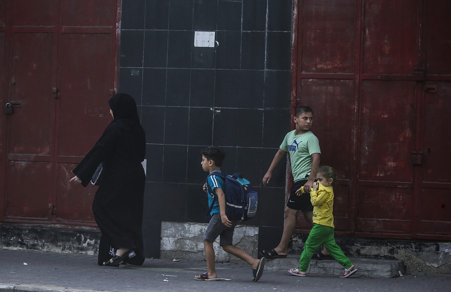 Una madre palestina y sus hijos abandonan su casa por un ataque aéreo de Israel. 