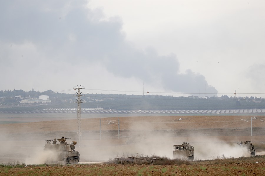 Soldados israelíes en vehículos militares maniobran en una zona a lo largo de la frontera con Gaza