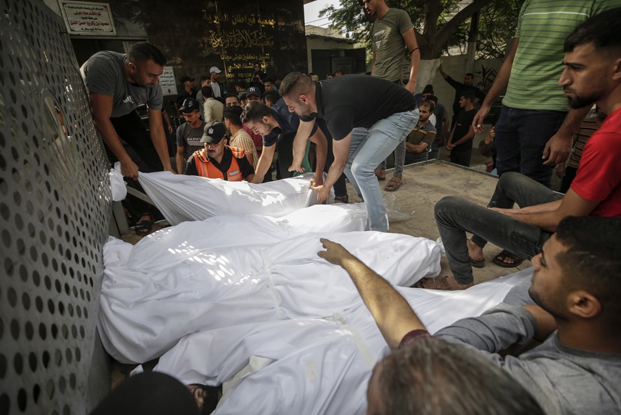La gente se reúne cerca de los cuerpos de palestinos muertos en el hospital Al-Shifa en la ciudad de Gaza