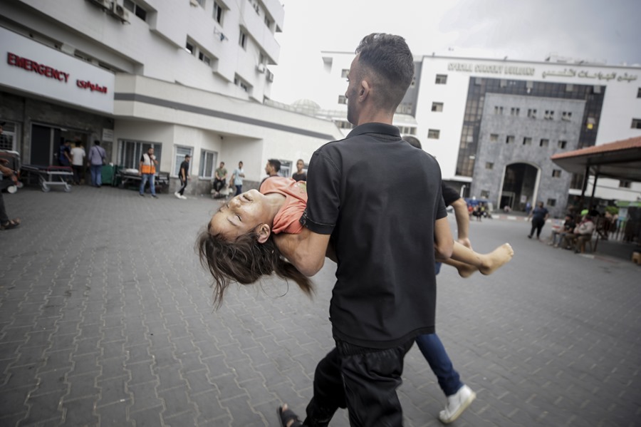 Un palestino lleva a un herido en el hospital Al-Shifa en la ciudad de Gaza