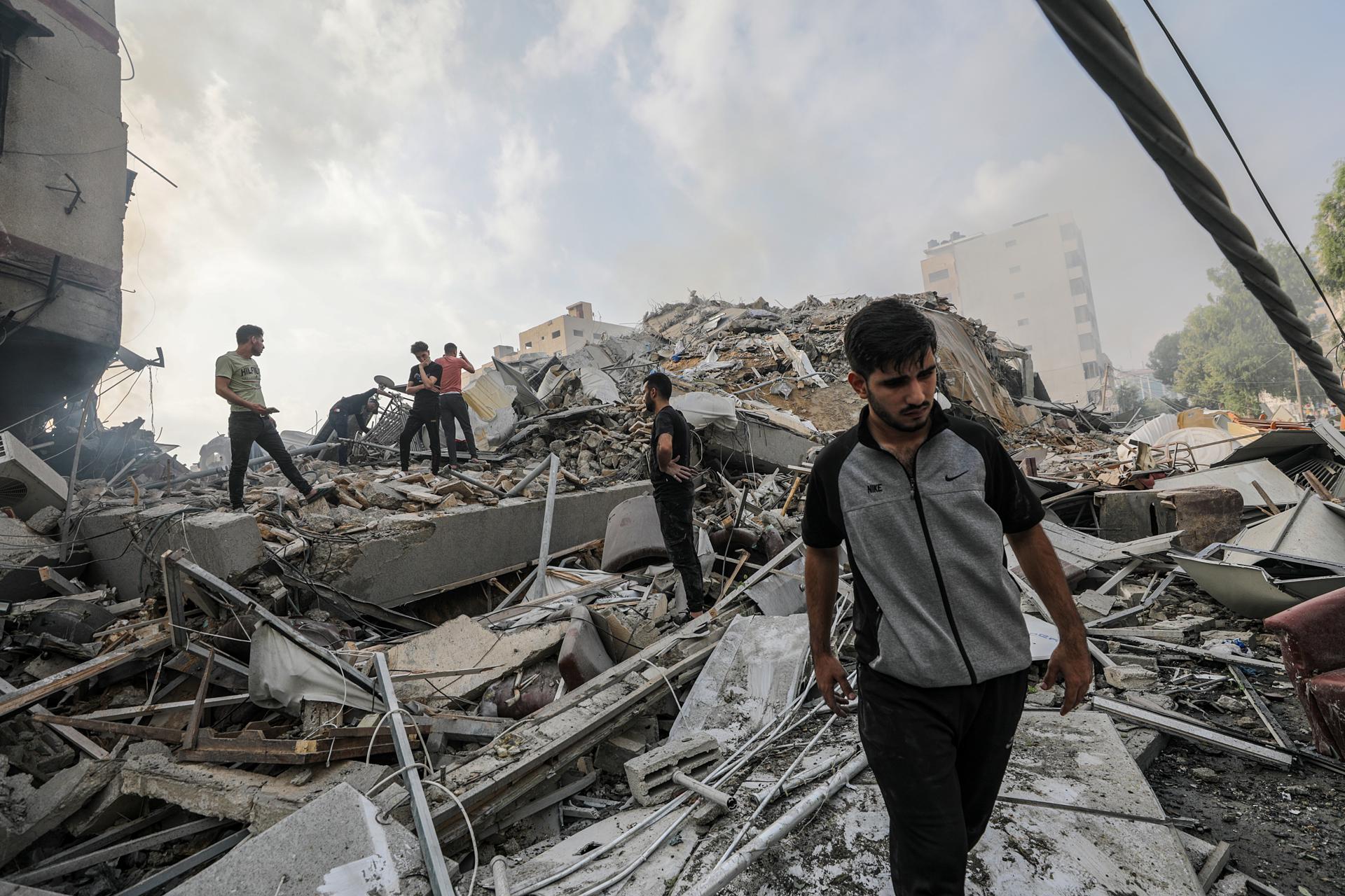 Palestinians inspect the rubble of their destroyed homes near Al-Watan Tower in Gaza City, 08 October 2023, following Israeli air strikes. EFE/EPA/MOHAMMED SABER