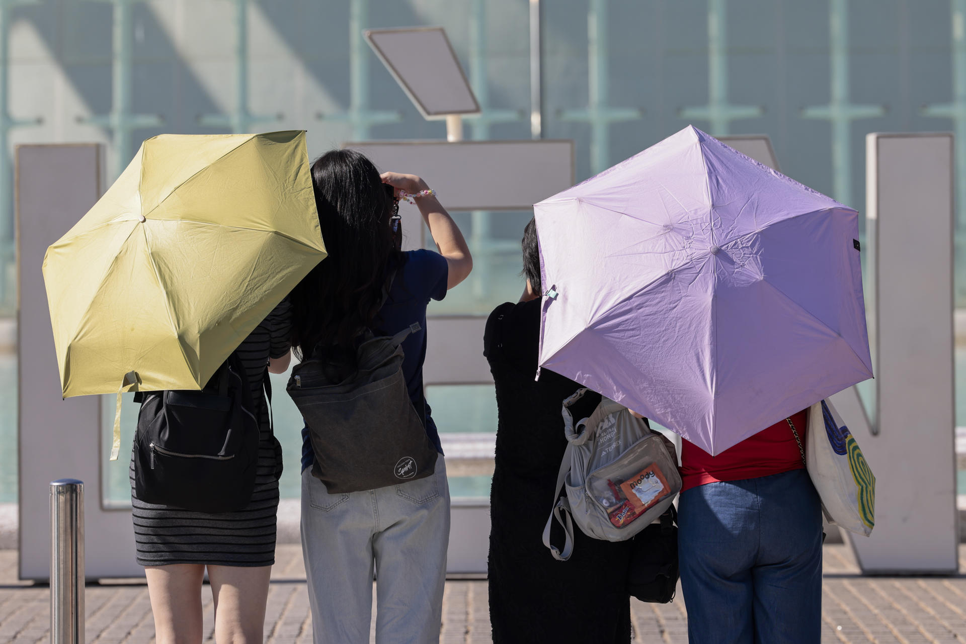 Varias personas se protegen del sol y del calor con parasoles. EFE/Ana Escobar