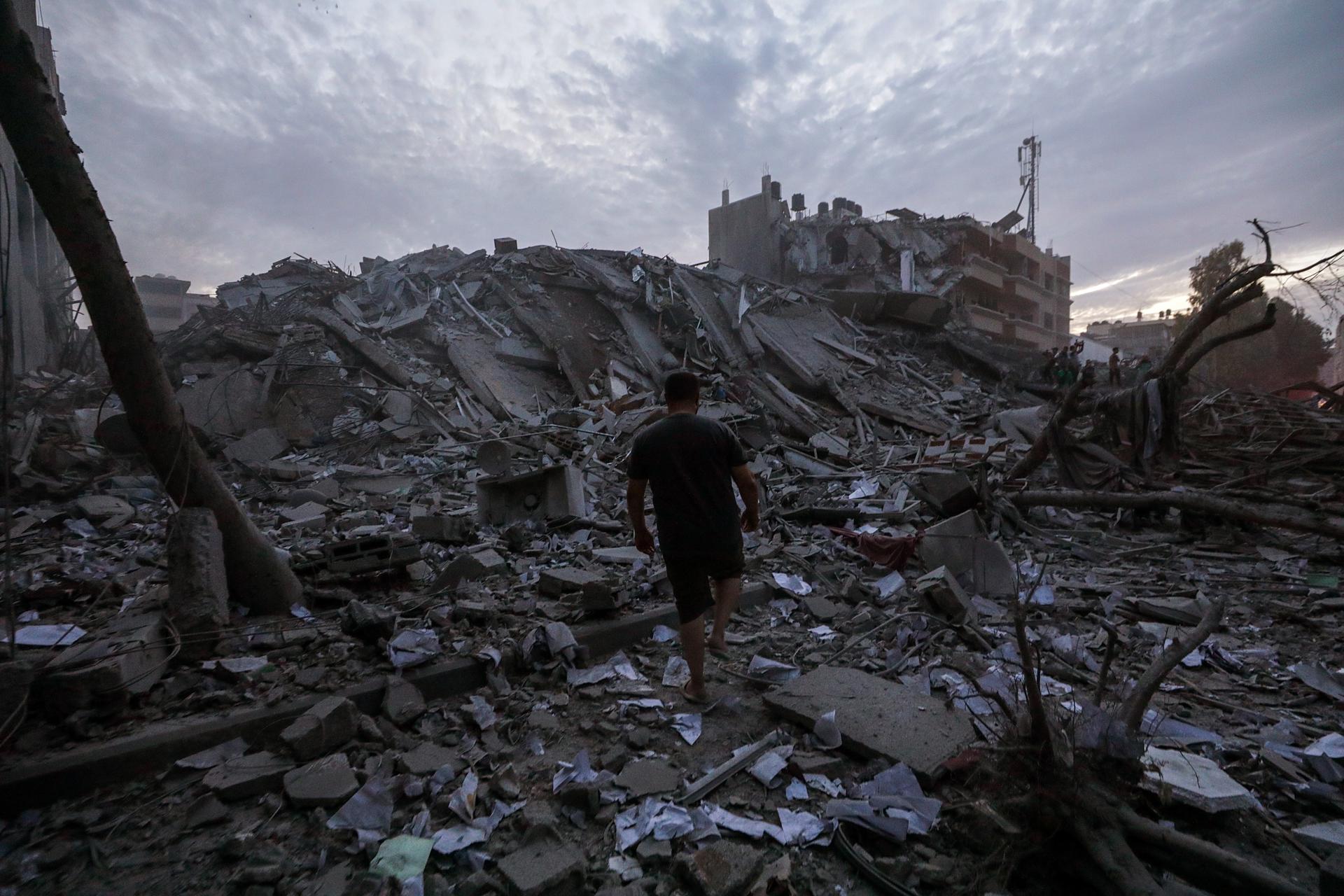 Palestinians inspect the destroyed surrounding of the Palestine Tower after Israeli warplanes targeted it in Gaza City, 07 October 2023. Rocket barrages were launched from the Gaza Strip early 07 October in a surprise attack on Israel claimed by the Islamist movement Hamas. IEFE/EPA/MOHAMMED SABER