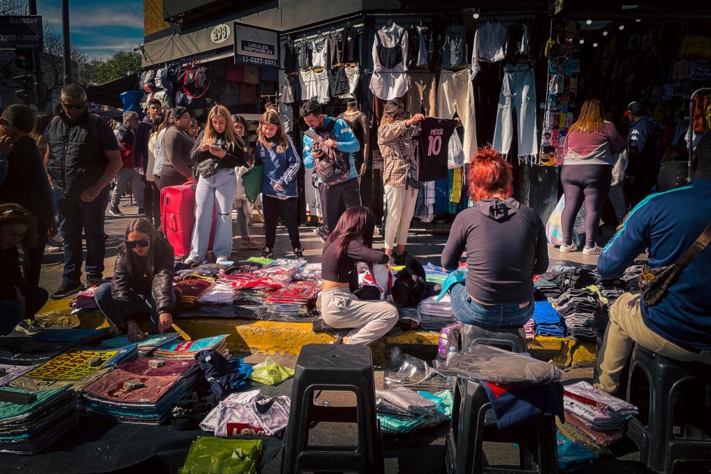 Varias personas compran ropa en un puesto callejero en el Barrio de Flores, el 3 de octubre 2023, en Buenos Aires (Argentina). EFE/ Juan Ignacio Roncoroni
