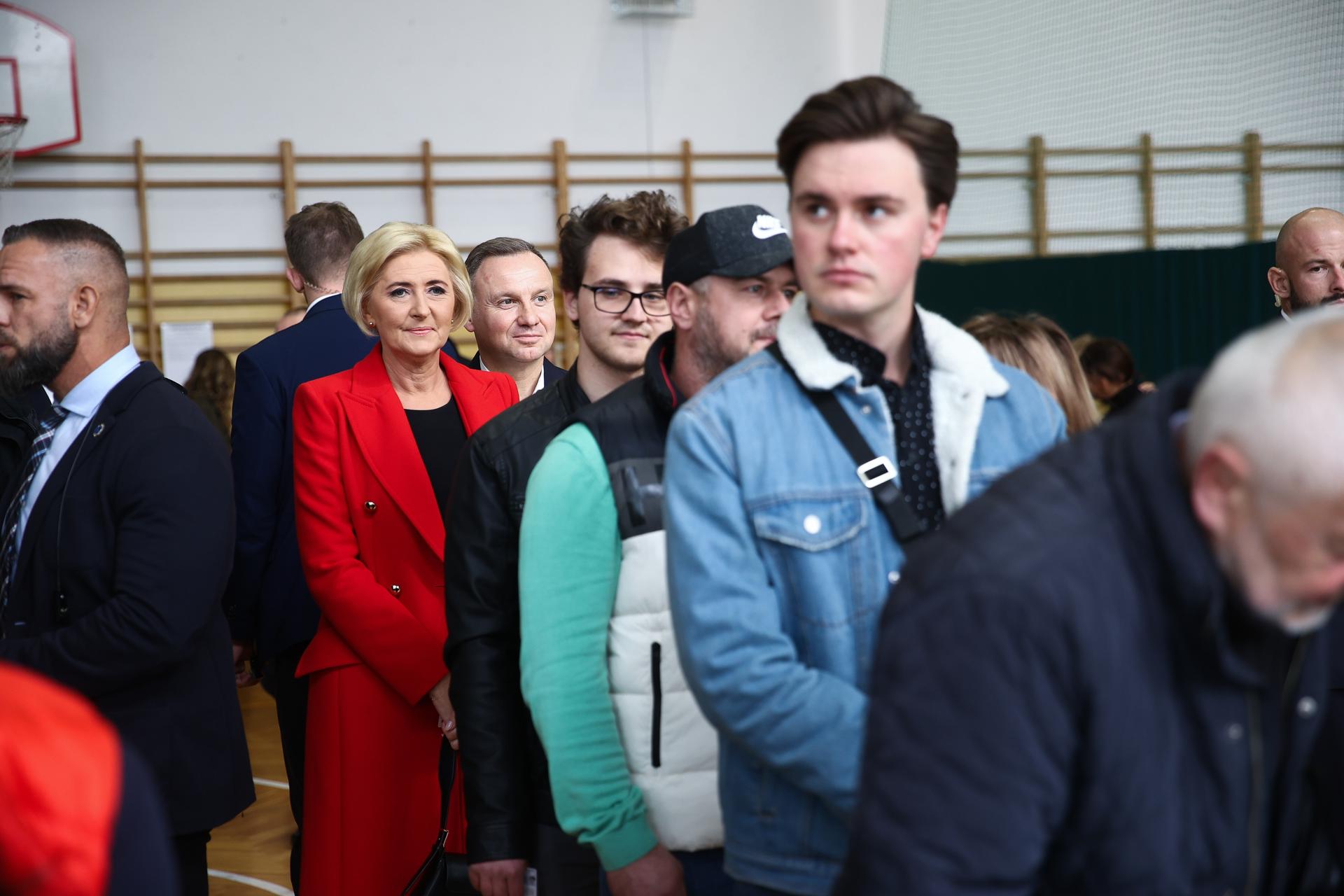 Polish President Andrzej Duda (C-R) and his wife Agata Kornhauser-Duda (C) wait in line with others to vote at a polling station in Krakow, Poland, 15 October 2023.  EFE/EPA/Lukasz Gagulski POLAND OUT